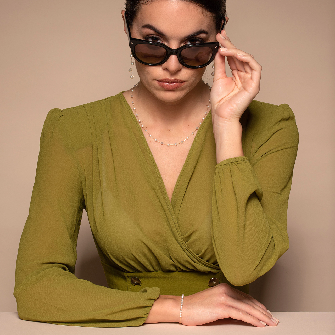 Perle in autunno Perle in autunno: donna con abito verde oliva, collana, orecchini e bracciale di perle