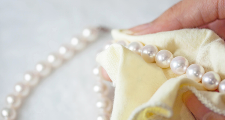 Perle in autunno Pulizia di una collana di perle con un panno morbido